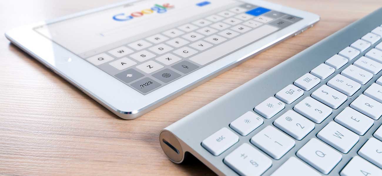 Tablet displaying Google search interface alongside a sleek keyboard, emphasizing the importance of search engine optimization in inbound marketing strategies.
