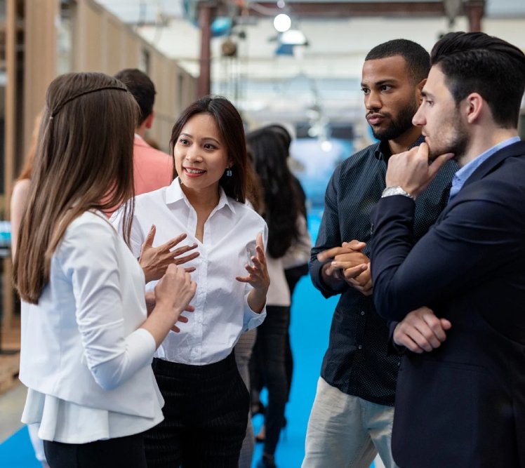 Group of professionals engaging in conversation at a business event, discussing AI receptionist solutions and customer service automation.
