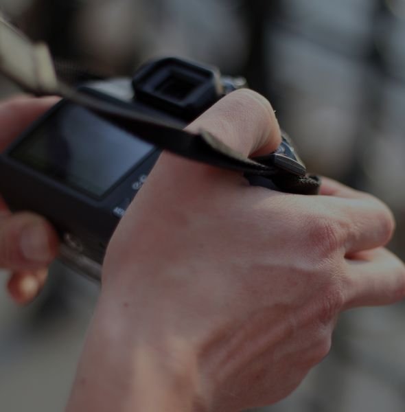 Person holding a camera, preparing to capture images, illustrating real estate photography services supported by AI communication tools.
