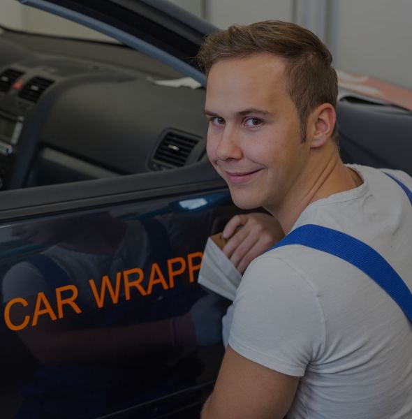 Smiling car wrapper applying vehicle wrap with "CAR WRAPPER" text visible, representing professional services for vehicle wrap companies. Smiling car wrapper applying vehicle wrap with "CAR WRAPPER" text visible, representing professional services for vehicle wrap companies.